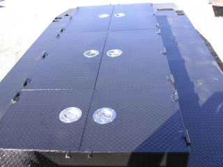 Custom trailer designed for mvoing track loader with storage units designed to fit under loader.
