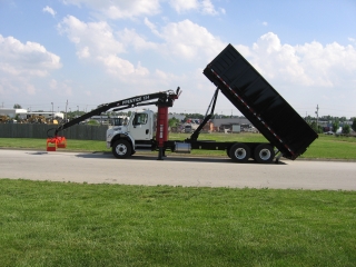Prentice 2124 shown extended and grappled parked on ground in front of truck.&nbsp; Bed is shown in dump mode.