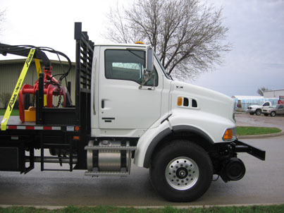 Passenger side view of Prentice 2124 mounted on Sterling chassis with option hi-rail gear
